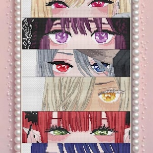 May include: A cross-stitch artwork featuring six sets of anime-style eyes with varying colors of hair and eyes. The artwork is framed with a pearl border and set against a pink background. The eyes include blonde, purple, silver, and red hair.
