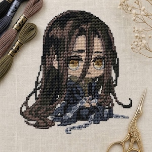 May include: A cross-stitch design of a seated anime-style character with long brown hair and large yellow eyes, wearing a dark blue outfit. Embroidery threads in brown, black, and green are in the upper left. Gold scissors are in the lower right.