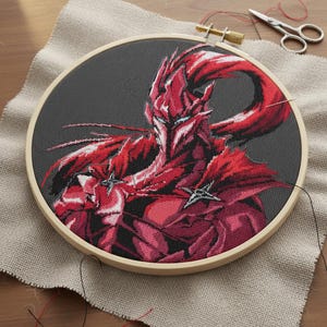 Könnte beinhalten: Fertiggesticktes Kreuzstich-Projekt mit einem roten und schwarzen Fantasy-Charakter in einem Holzrahmen. Nadel und Faden sind noch vorhanden, Schere liegt daneben. Der graue Hintergrund zeigt die detaillierte Handwerkskunst.