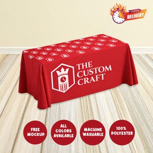 May include: A red rectangular tablecloth with a repeating white logo pattern. The tablecloth features the text "THE CUSTOM CRAFT" in white. Additional circular graphics state "FREE MOCKUP", "ALL COLORS AVAILABLE", "MACHINE WASHABLE", and "100% POLYESTER".