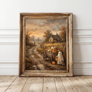 May include: A framed wall art print depicting a rural autumn landscape with a dirt path, a small house, and a wooden cart filled with orange pumpkins. A white ghost figure stands beside the cart holding a glowing lantern near a jack-o'-lantern.