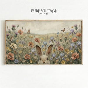 May include: A framed print featuring a field of wildflowers in soft pastel colors, with a rabbit peeking out from the flowers. Butterflies flutter among the blooms. The text "PURE VINTAGE PRINTS" is at the top.