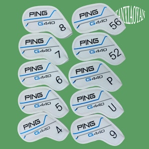 Puede incluir: Un conjunto de fundas blancas para palos de golf con la marca "PING" y "G440" impresas. Cada funda tiene un número o letra en negro: 4, 5, 6, 7, 8, 9, 52, 56, P y U. El diseño incluye detalles en azul y gris.