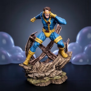 Può includere: Una dettagliata statuetta da collezione di un supereroe che indossa una tuta blu e gialla con una visiera rossa, in posa dinamica su una base rocciosa piena di detriti con una grande struttura metallica a forma di X dietro.