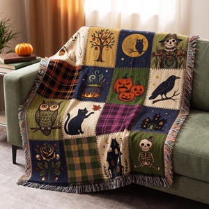 May include: A woven throw blanket featuring a patchwork design with various illustrations including a ghost, an apple tree, an owl, a scarecrow, a cauldron, pumpkins, a raven, a black cat, a haunted house, a rose with skulls, and a skeleton.