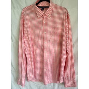 May include: A long-sleeve button-down shirt featuring a light pink and white gingham check pattern. The shirt includes a pointed collar, a single chest pocket on the left side, and a full-length front button placket with white buttons.