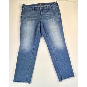 May include: Light blue denim jeans with a faded wash and frayed hem. The jeans have two front pockets and a button and zipper closure. The denim pants are a classic style.