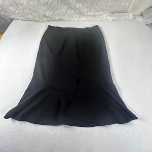 May include: A black midi skirt with a flared hem. The skirt has a fitted waist and a subtle seam detail down the front. The fabric appears to be a smooth, solid color, suitable for various occasions.