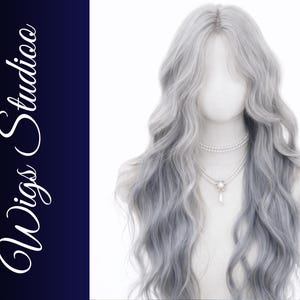 May include: A long, wavy, silver-gray wig on a mannequin head. The wig has a gradient effect, transitioning to a darker gray at the ends. A double-strand pearl necklace with a pendant adorns the mannequin's neck. The words "Wigs Studio" are written in white script.