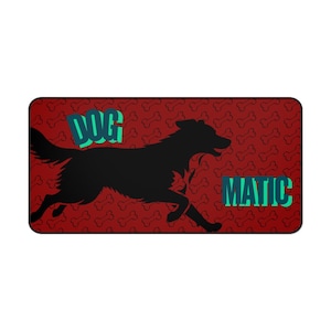 Può includere: Tappetino rettangolare con sfondo rosso con un motivo ripetuto di ossa di cane bianche. Una silhouette nera di un cane che corre è centrata, con la parola "DOG" sopra e "MATIC" sotto, in lettere a blocchi turchesi.