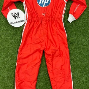 Pode incluir: Macac&atilde;o de corrida vermelho com detalhes brancos, com o nome "HAMILTON" e o logotipo da HP. O macac&atilde;o tem gola e punhos brancos, e uma faixa branca nas laterais. Ideal para desportos motorizados.