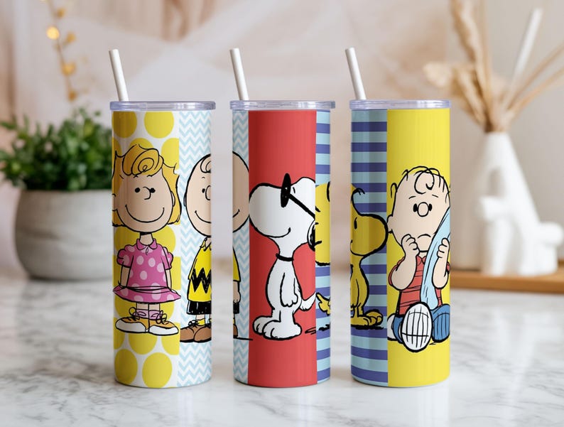 Puede incluir: Tres vasos de acero inoxidable con pajitas blancas, con personajes de Peanuts. Un vaso tiene a Sally Brown, otro a Snoopy y el tercero a Charlie Brown. Los vasos tienen fondos amarillos, rojos y azules con dise&ntilde;os de personajes.