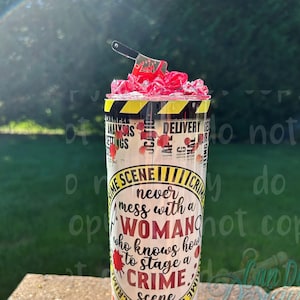 May include: A yellow and black tumbler with a crime scene tape design. The tumbler has the text "Never mess with a woman who knows how to stage a crime scene".