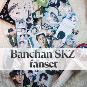 May include: A collection of Stray Kids Bang Chan photo cards, stickers, and a white light stick. The items feature various portraits of the artist, including a photo strip, square prints, and circular stickers with text and graphic illustrations.