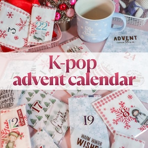 Op de afbeelding: Een K-pop adventskalenderset met meerdere kleine witte papieren enveloppen versierd met rode en blauwe sneeuwvlokpatronen, vakantie-illustraties en genummerde labels, inclusief een lichtblauwe mok met sneeuwvlokken.