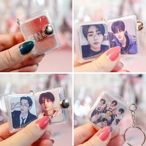 May include: Clear plastic mini photo album keychains. Each keychain features a small album with photos of people. The albums are held together with a silver metal clasp and attached to a silver keyring.