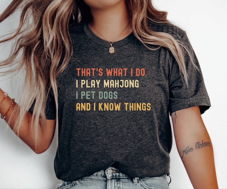A woman wearing a gray t-shirt with text printed on it.