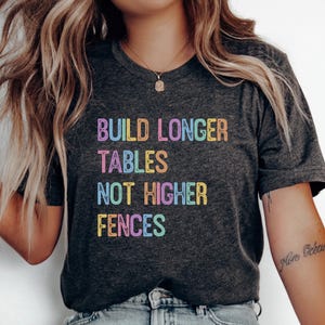 May include: A white ceramic mug with a black handle and the text "But First, Coffee" in a handwritten style. The mug is on a white surface. The mug is 10 cm tall.