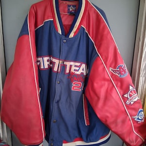 May include: A blue and red varsity jacket featuring the text FIRST TEAM and the number 24 on the front. The sleeves are red with white piping and various embroidered patches, including an Atlanta logo, a baseball graphic, and a letter N emblem.