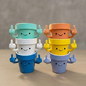 May include: A stack of six colorful, smiling flower pots, each with arms and hands giving the middle finger. The pots are in shades of blue, white, yellow, orange, and teal. The pots have black dot eyes and curved smiles.
