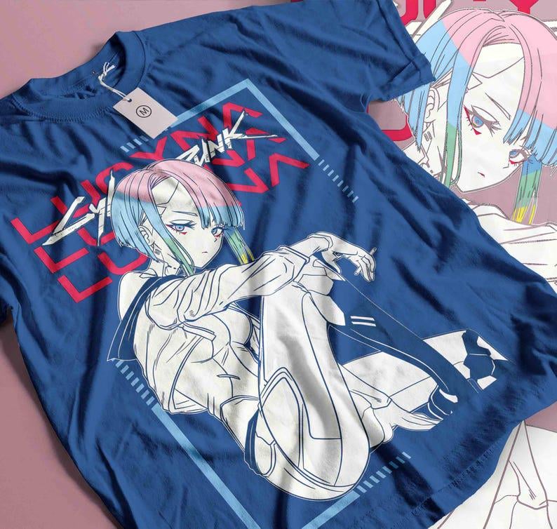 May include: A navy blue t-shirt with a graphic of an anime character with blue, pink, and green hair. The text "Cyberpunk" is in red and white. The design is framed in a light blue rectangle.
