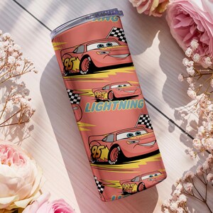May include: A stainless steel tumbler featuring a repeating pattern of the animated character Lightning McQueen from the movie Cars. The design includes the number 95, a checkered flag, and the word "Lightning" on a coral background.