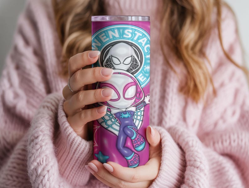 May include: A tall, cylindrical tumbler featuring a vibrant design of a superhero character. The tumbler is primarily pink and purple, with the character's image prominently displayed. The text "WEN STAC" is visible at the top. The tumbler is held by a person.