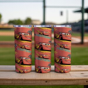 May include: Three stainless steel tumblers with a repeating pattern of the character Lightning McQueen from the animated movie Cars. The tumblers are red with yellow and black accents and the text "Lightning".
