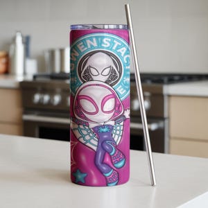 May include: A tall, cylindrical tumbler with a vibrant design featuring the character Gwen Stacy. The tumbler is primarily pink with a teal and white circular emblem. A silver-colored straw rests against the side. The tumbler is approximately 8 inches tall.