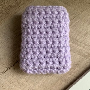 May include: A small, lavender crocheted pouch. The pouch is made with a single crochet stitch and has a smooth, textured surface.