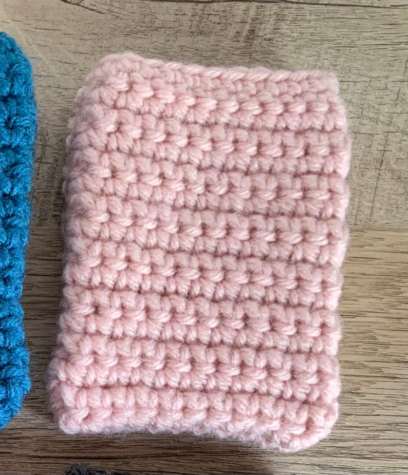 K&ouml;nnte beinhalten: Ein rosa geh&auml;keltes Quadrat, m&ouml;glicherweise ein Untersetzer oder eine kleine Decke.