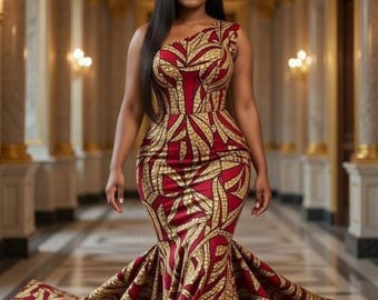 Puede incluir: Un vestido formal de un solo hombro con un vibrante estampado rojo y dorado. El vestido presenta un corpiño ajustado, una falda de sirena acampanada y una cola dramática. La modelo está de pie en un gran salón con columnas ornamentadas e iluminación cálida.