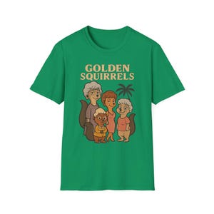 Puede incluir: Una camiseta verde con el texto "GOLDEN SQUIRRELS" y una ilustración de dibujos animados de cinco personajes de ardillas. Las ardillas están representadas con diferentes atuendos, con un gráfico de palmera. La camiseta es de material suave.