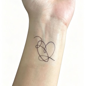 May include: A black line art tattoo of a heart shape on a wrist. The heart is formed by a continuous, looping line. The skin tone is light, and the background is plain white.