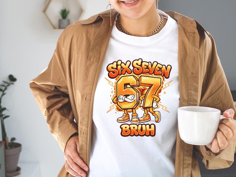 May include: White t-shirt featuring a cartoon graphic with the text "SIX SEVEN BRUH". The numbers 6 and 7 are anthropomorphic characters in orange and yellow, with lightning bolts. The shirt is worn by a person.