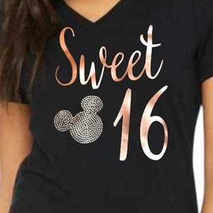 May include: A black V-neck t-shirt featuring the rose gold text Sweet 16 and a mouse-ear silhouette graphic filled with small circular patterns. The text Colors may be Customized is printed in the upper left corner of the garment.