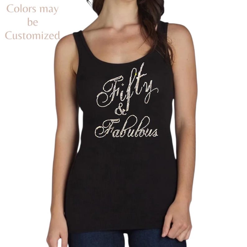 May include: Black tank top with the text "Fifty & Fabulous" in a cursive font. The text is embellished with small, sparkling accents. The words "Colors may be Customized" are in the upper left corner.