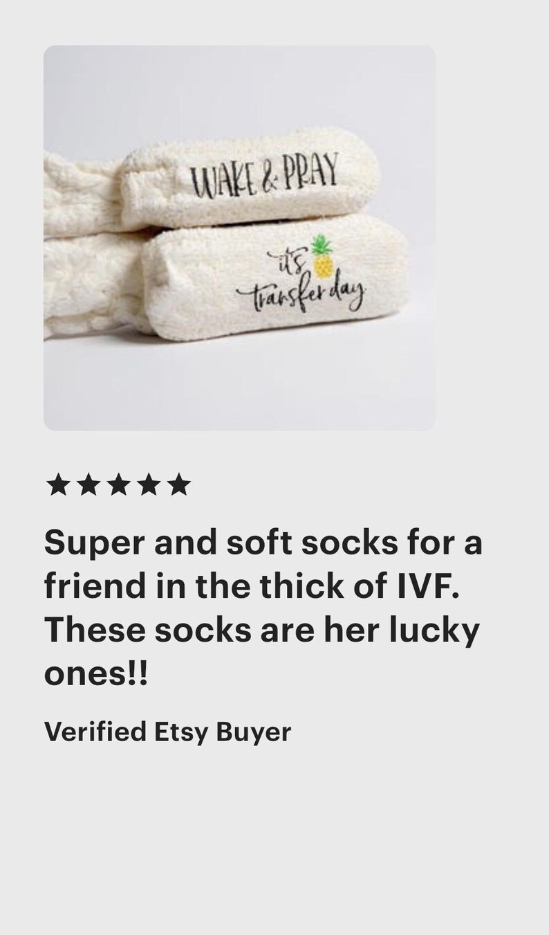 May include: White, fluffy socks with the phrases "WAKE & PRAY" and "it's transfer day" printed in black script. A pineapple graphic accompanies the second phrase. These socks are a thoughtful gift.
