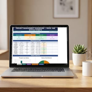 May include: A laptop displaying a project management dashboard in Excel and Google Sheets. The screen shows project status, including total projects, in progress, completed, and high priority. A white mug and a potted succulent sit nearby.