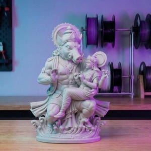 Pode incluir: Estátua detalhada, em branco sujo, retratando duas figuras. Uma figura tem cabeça de javali e segura a outra, que toca uma flauta. A estátua é intrincadamente esculpida com detalhes ornamentados e assenta sobre uma base decorativa.