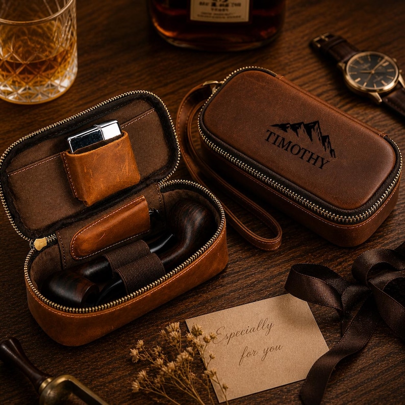 Puede incluir: Dos estuches de cuero marr&oacute;n para pipa, uno abierto con una pipa y un encendedor, el otro cerrado con "TIMOTHY" y un gr&aacute;fico de monta&ntilde;a. Tambi&eacute;n se ven un reloj, un vaso de whisky y una tarjeta que dice "Especially for you".