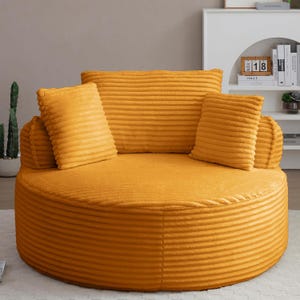 Puede incluir: Un sof&aacute; redondo de pana amarillo mostaza con cojines a juego. El sof&aacute; tiene un perfil bajo y un asiento ancho y circular. El respaldo es un coj&iacute;n grande y rectangular, y hay cuatro cojines cuadrados m&aacute;s peque&ntilde;os. El sof&aacute; est&aacute; dise&ntilde;ado para la comodidad.