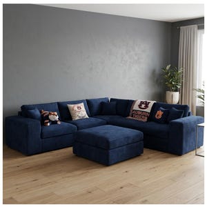 May include: A navy blue corduroy sectional sofa with an ottoman. The sofa has several throw pillows and a blanket with the words "Auburn Tigers" on it. A stuffed tiger toy is on the sofa.