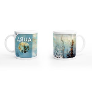 May include: White ceramic mug with a blue and abstract design. The mug features the word "AGUA" in white text on a blue background. The other side of the mug has an abstract design with blue, white, and brown colours.