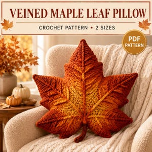 May include: A crochet pattern for a veined maple leaf pillow in two sizes. The image features a textured, leaf-shaped pillow with a gradient of deep red, orange, and yellow yarn. Text reads: VEINED MAPLE LEAF PILLOW, CROCHET PATTERN, 2 SIZES, PDF PATTERN.