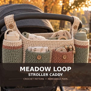 May include: A crochet stroller caddy in cream, sage green, and terracotta featuring two side bottle holders, two front pockets with wooden buttons, and two top straps with buttons. The text MEADOW LOOP STROLLER CADDY CROCHET PATTERN REMOVABLE PODS is visible.