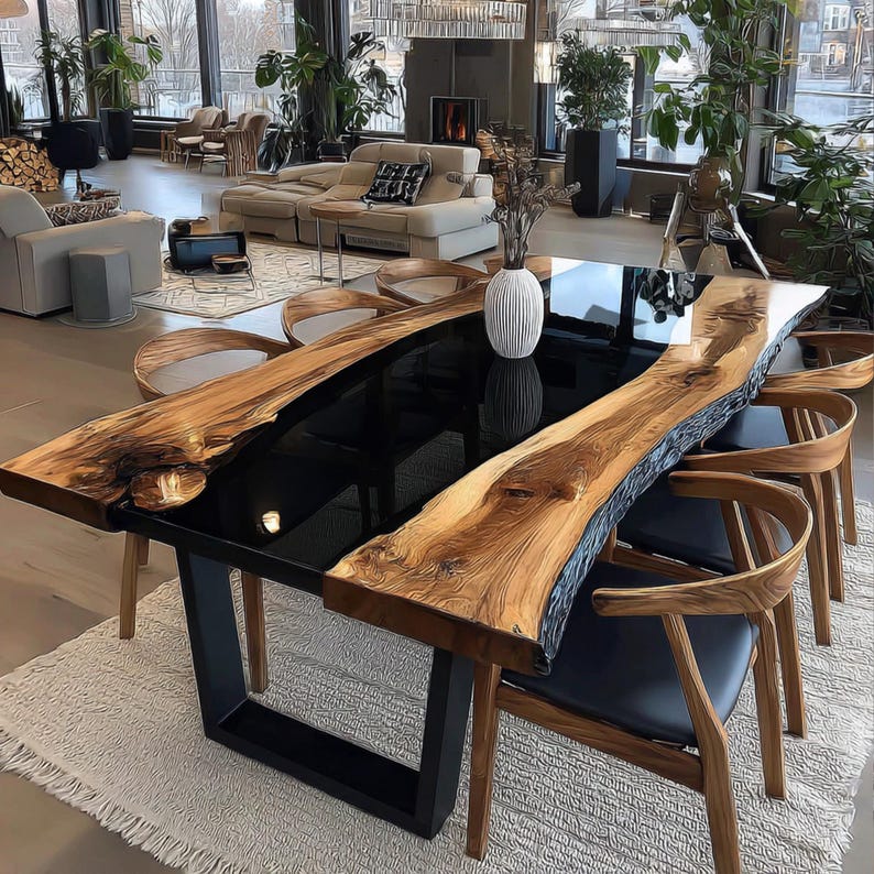 Op de afbeelding: Een grote, moderne eettafel met een zwart epoxy middenstuk en zijkanten van levend hout. De tafel wordt ondersteund door een zwarte metalen basis en is omringd door houten stoelen met zwarte zittingen. De tafel is ongeveer 254 cm lang.