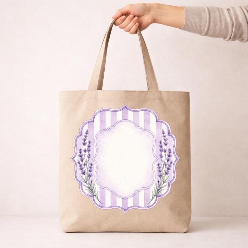 May include: A beige tote bag featuring a central decorative label design. The graphic includes vertical light purple and white stripes, a scalloped frame, and watercolour-style lavender sprigs on the left and right sides of the blank centre.