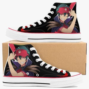 May include: Black high-top sneakers with a red and white sole. The sneakers feature a colorful anime character design on the sides. The shoes have white laces and a red stripe around the sole.