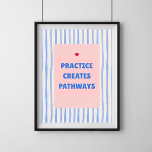 Puede incluir: Una impresión artística enmarcada con un marco negro. La obra de arte presenta un fondo a rayas azul claro y blanco. Una forma rosa con bordes festoneados en el centro contiene las palabras "PRACTICE CREATES PATHWAYS" en azul, con un corazón rojo encima.